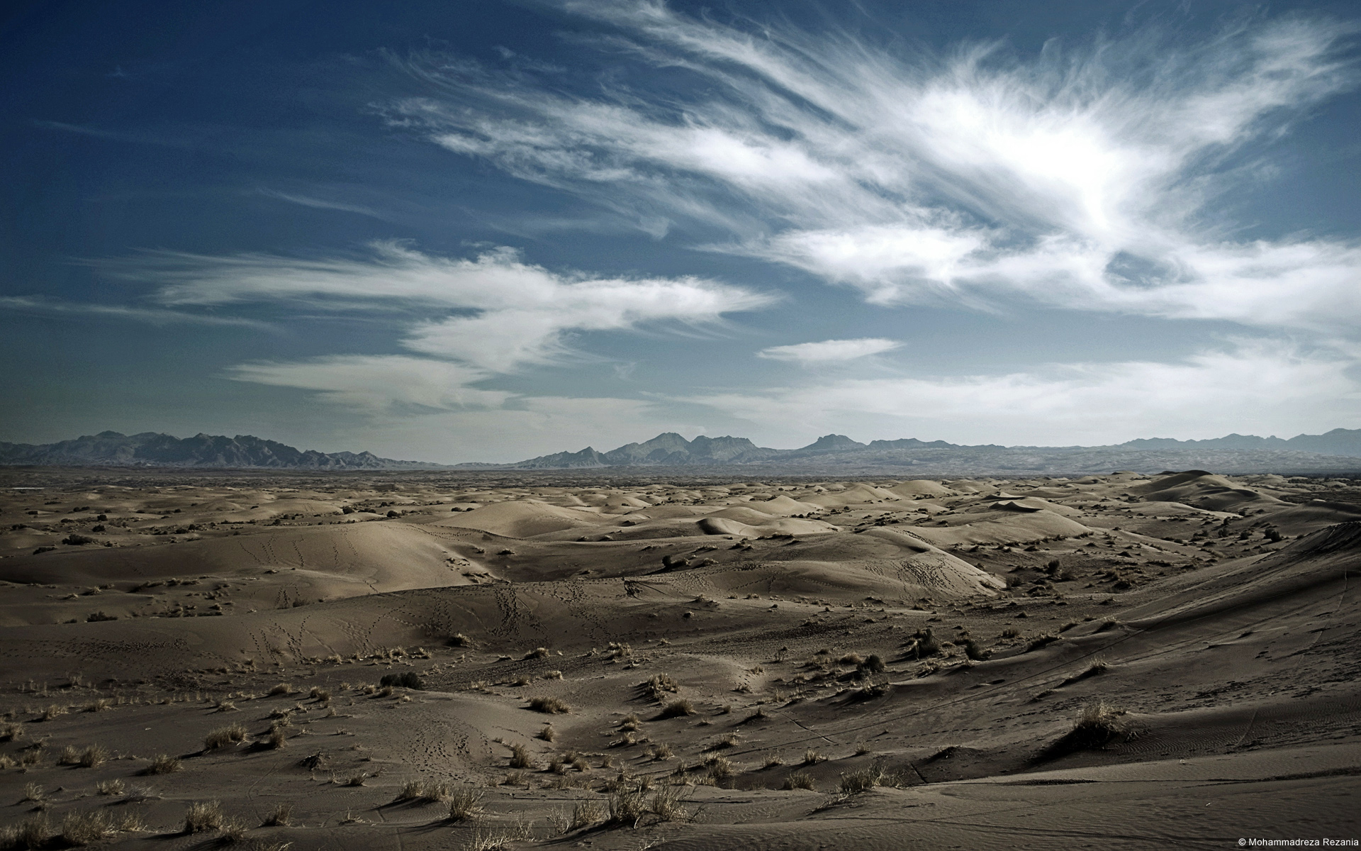 Wundervolle Landschaften erwarten uns im Iran, lange Wolken auf dunkle blauen Himmel über wundervoller Wüstenlandschaft